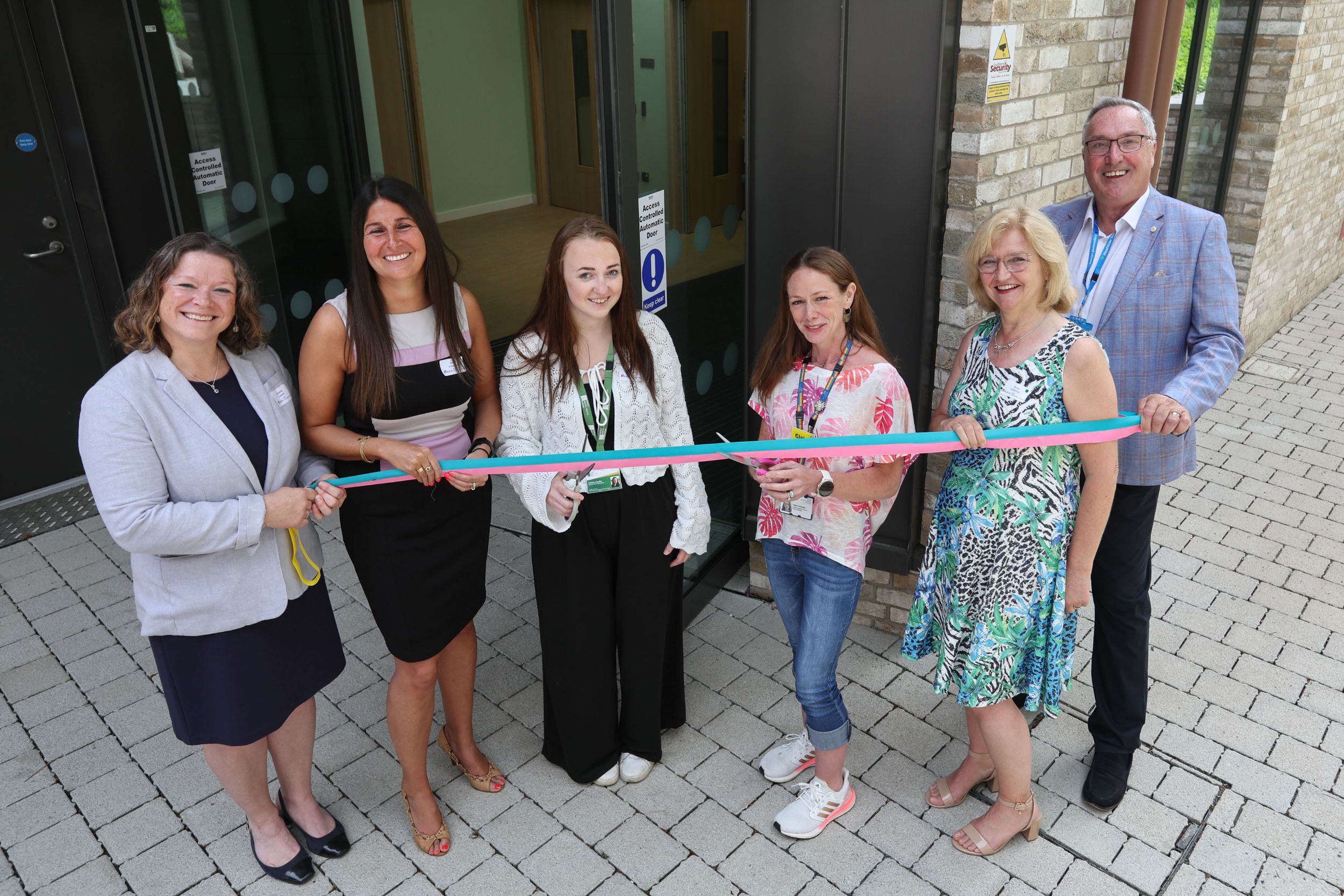 Seastone opening 4 People standing infront of a door, cutting a ceremonial ribbon together